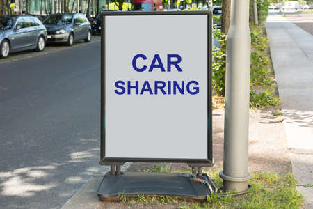 Car sharing sign on board by street in cityの写真素材