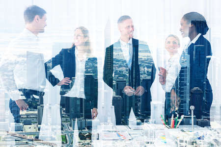 Double exposure of smiling business people in office and buildingsの写真素材