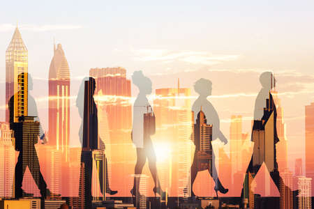 Double exposure of silhouette business people and modern buildings during sunsetの写真素材