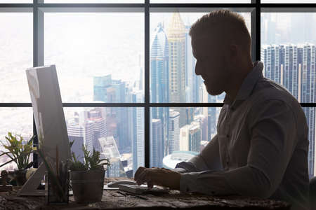 Young Businessman Using Keyboard In Modern Officeの写真素材