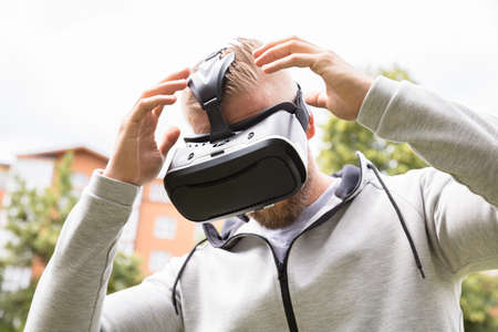 Close-up Of A Man Having Headache While Using Virtual Reality Headset Glasses