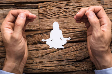 The Man's Fingers In Mudra Gesture With Lotus Pose Made Up Of White Cut-out Paperの写真素材