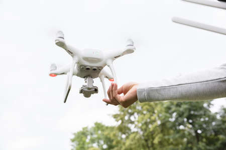 Close-up Of Hand Leaving The Flying Quadrocopter In The Parkの写真素材