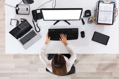 High Angle View Of A Businesswoman Working On Computer With Blank White Screen