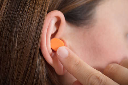 Close-up Of A Woman Putting Earplug Into Her Earの写真素材