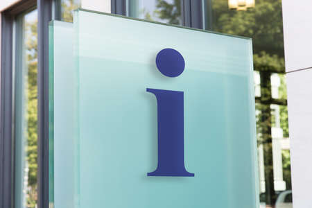 Closeup of information sign on glass board outside building in cityの写真素材