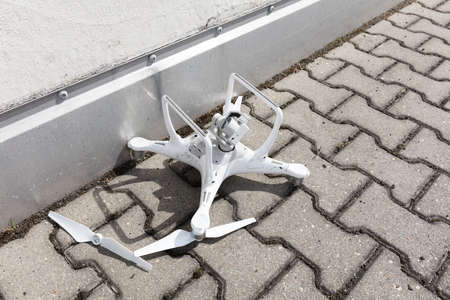 High angle view of broken drone on footpathの写真素材