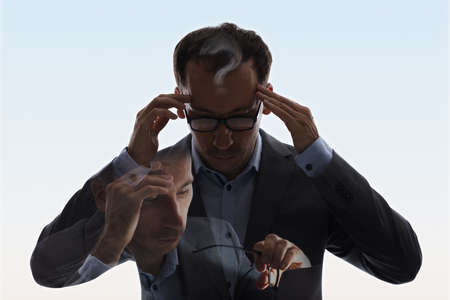 Double Exposure Of Businessman In Suit And Glasses Having Headacheの写真素材