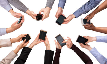 Elevated View Of Hands Using Cell Phone Against White Background