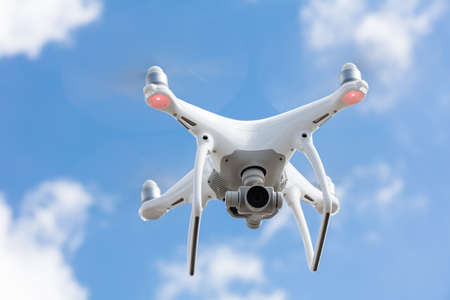 Low angle view of drone flying against blue sky
