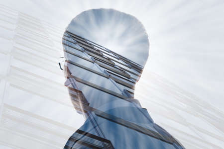 Double Exposure Of A Businessman And Skyscraper With Sunlight In Cityの写真素材