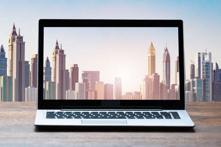 View Of Laptop On Table With Against City Building Skyscrapersの写真素材