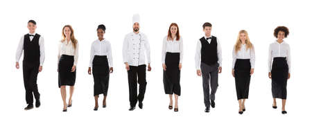 Team Of Happy Restaurant Staffs In Uniform Walking Over White Background