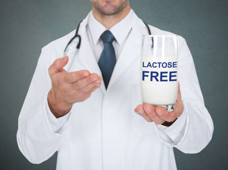 Close-up Of Doctor Holding Lactose Free Glass Of Milkの写真素材