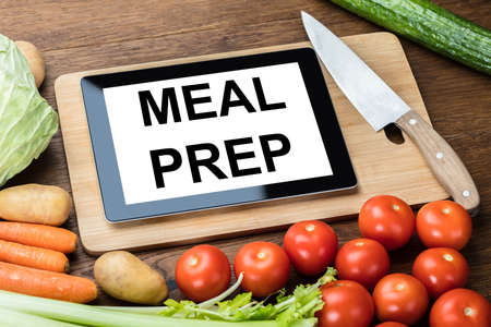 High Angle View Of Meal Preparation Text On Digital Tablet With Vegetables On Desk