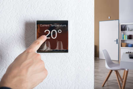 Finger Touching Digital Thermostat Temperature Controller At Homeの写真素材