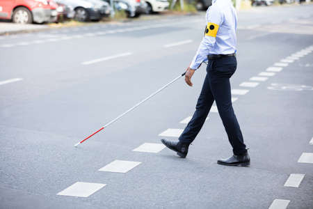Blind Person With White Stick Walking On Streetの写真素材