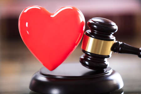 Close-up Of Red Heart And Gavel In Courtroomの写真素材
