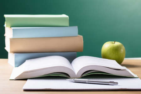 Close-up Of School Textbook On Desk In Front Of Blackboardの写真素材