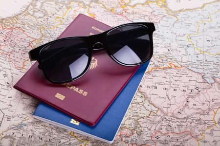 High Angle View Of Sunglasses And Passport On Map