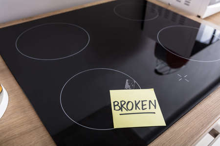 High Angle View Of Induction Stove With Adhesive Notes Showing Broken Textの写真素材