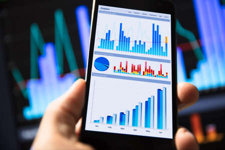 Businessperson With Mobile Phone Showing Graph On Screenの写真素材