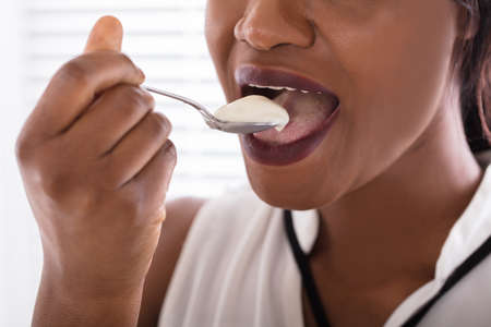 Close-up Photo Of A Woman Eating Yogurt