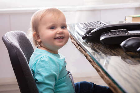 Portrait Of Cute Smiling Baby Girl Sitting On Chair
