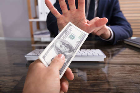 Cropped Hand Of Businessperson Refusing To Take Bribe From Partner At Workplace