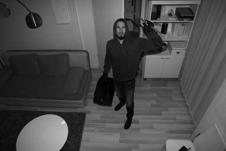 High Angle View Of A Robber Breaking CCTV Camera In Vacant Houseの写真素材