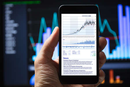 Human Hang Using Mobile Phone With Stock Charts On Screen