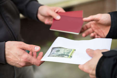 Human Hand Giving Banknote And Buying Illegal Foreign Passportの写真素材