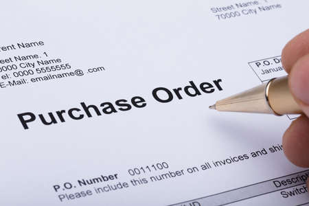 Close-up Of A Person Hand Filling A Purchase Order Formの写真素材