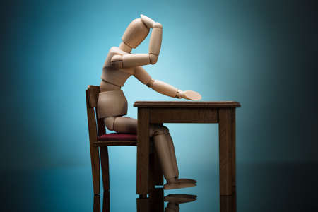 Wooden Dummy Figure Suffering From Headache Sitting On Chairの写真素材