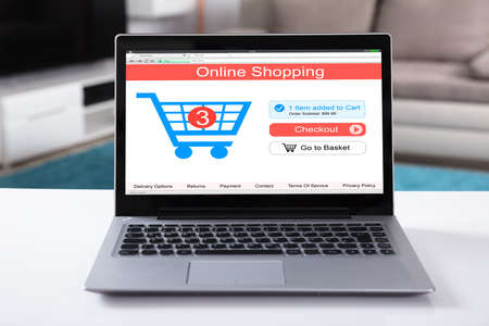 Close-up Of Online Shopping Website On Laptop Over White Deskの写真素材