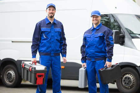 Portrait Of A Happy Young Male Worker Holding Toolboxの写真素材