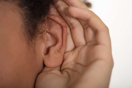 Close-up Of Person Trying To Hear With Hand Over Earの写真素材