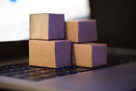 Close-up Of Small Cardboard Boxes On Laptop Keypadの写真素材