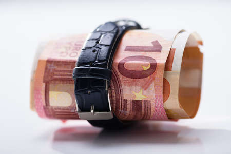 Rolled Up Ten Euro Banknotes Tied With Belt Against White Backgroundの写真素材