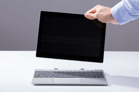 Human Hand Connecting Digital Tablet With Blank Screen To Keypadの写真素材
