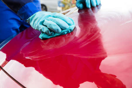 Young Happy Male Worker Cleaning Red Car With Clothの写真素材