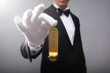 Close-up Of A Receptionist's Hand Holding Hotel Door Key