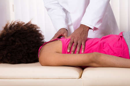 Close-up Of Physiotherapist's Hand Giving Back Massage To Female Patient In Clinicの写真素材
