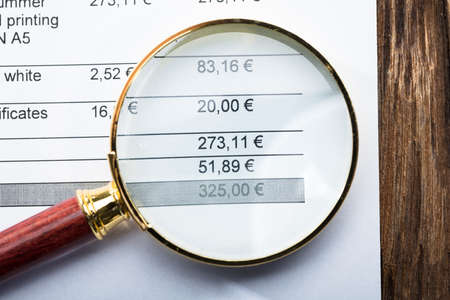 Close-up Of An Invoice Text Seen Through Magnifying Glassの写真素材
