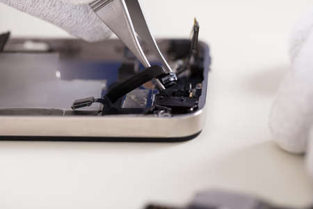Close-up Of A Tweezers Changing Broken Camera Of Mobil Phoneの写真素材