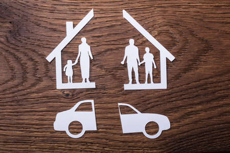 White Paper Cutout Of A Family Split Apart With Car On Wooden Backgroundの写真素材