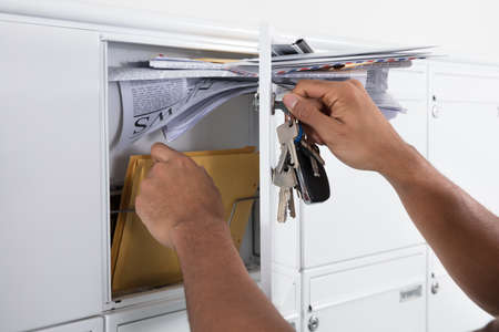 Close-up Of A Person's Hand Opening Mailbox With Key And Taking Letters