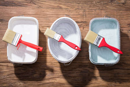 Different Size Of Paint Brush And Container In A Row On Wooden Deskの写真素材