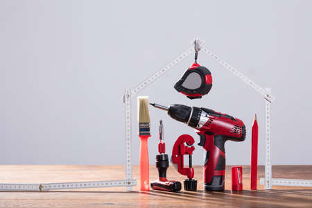 Close-up Of Repairs Tools Under The House Made With Measuring Tape On The Wooden Tableの写真素材