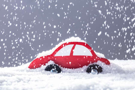 Red Car Covered With Snow In Heavy Snowfallの写真素材